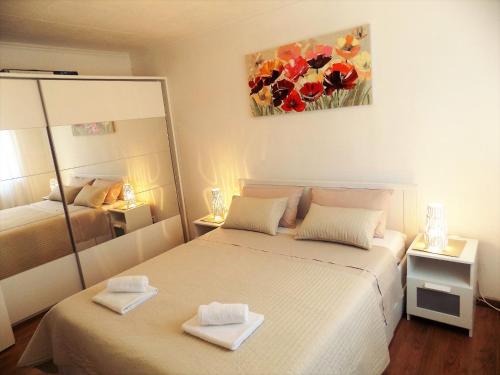 a bedroom with two beds and a painting on the wall at Apartment Anamarija in Njivice