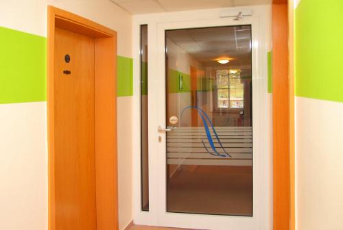 a bathroom with a glass door with a hose at Hotel Müritzterrasse in Röbel