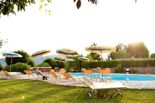 a group of chairs and umbrellas next to a pool at Casa Di Campagna In Toscana in Sovicille