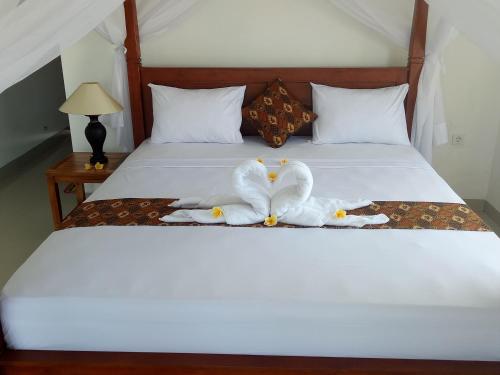 Dos cisnes hechos de toallas en una cama en Minory Guesthouse, en Amed
