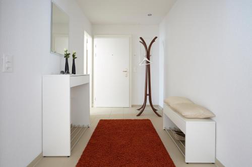 a living room with white walls and a red rug at CITY STAY - Nordstrasse in Zürich