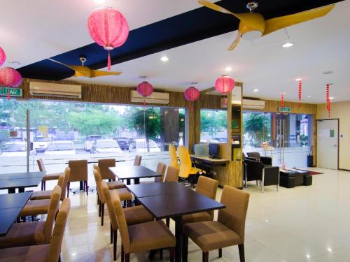 un ristorante con tavoli, sedie e lampade rosa di Eight Days Boutique Hotel - Mount Austin a Johor Bahru