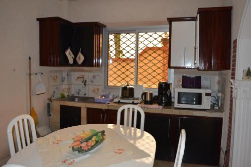 a kitchen with a table and a table and a microwave at Résidence Hotelière Borel Denver in Douala