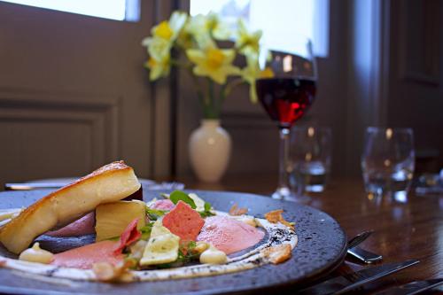 a plate of food on a table with a glass of wine at The Falcondale at Lampeter in Lampeter
