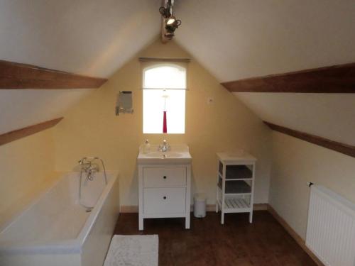 a bathroom with a sink and a tub and a window at Guillemont Halt in Guillemont