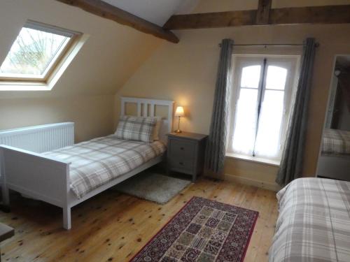 a bedroom with two beds and two windows at Guillemont Halt in Guillemont