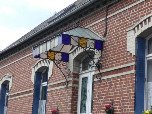 a stained glass window on the side of a brick building at Guillemont Halt in Guillemont
