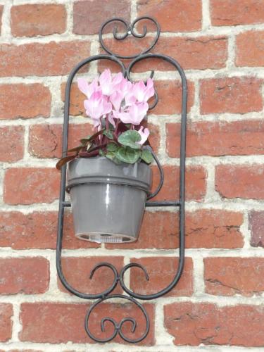 a flower pot hanging on a brick wall at Guillemont Halt in Guillemont