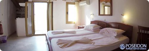 Un dormitorio con una cama con una pajarita. en Poseidon Studios, en Kokkari
