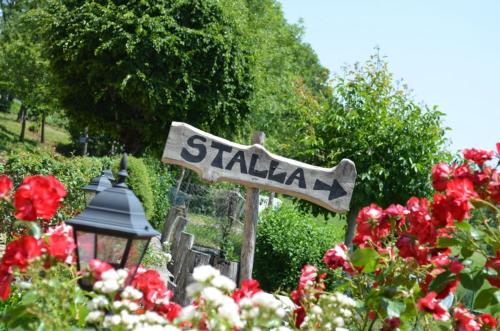 a sign in a garden with red flowers at Agriturismo dell'Altopiano in Serle