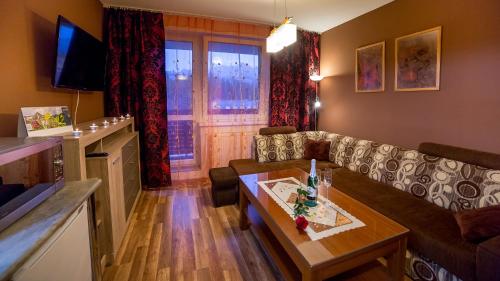 a living room with a couch and a table at High Tatras - Patris 27 in Tatranska Strba