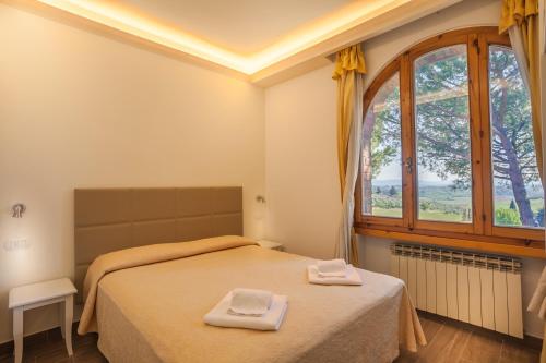 a bedroom with a bed with two towels on it at Hotel Villa San Giorgio in Poggibonsi