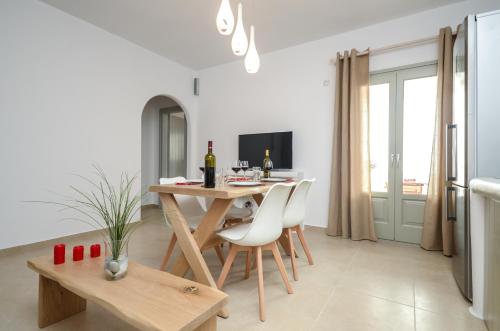 a kitchen and dining room with a table and chairs at Aphrodite Luxury Apartments in Agios Prokopios