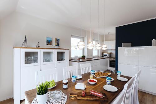 eine Küche und ein Esszimmer mit einem Holztisch mit Stühlen in der Unterkunft Zuhause am Meer in Büsum