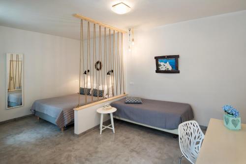 a bedroom with two beds and a table and chairs at Summer Time Villa in Fira