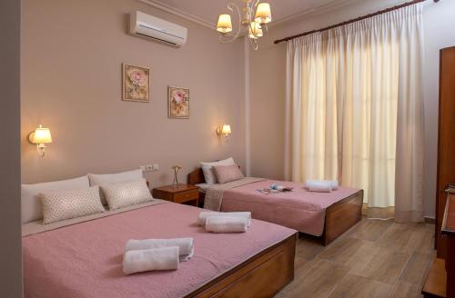 a room with two beds with pink sheets at Megas Alexandros in Paralia Katerinis