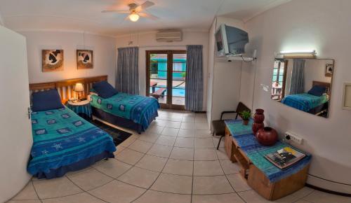 a room with two beds and a living room with a table at La Rochelle Inn in Richards Bay