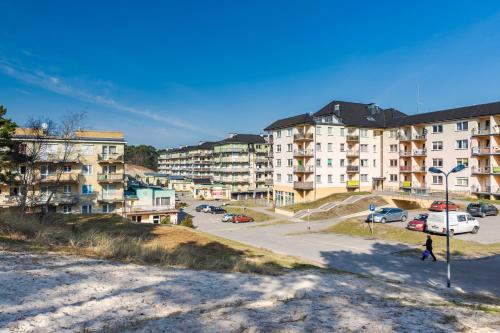 un grupo de edificios de apartamentos en un estacionamiento en Apartamenty Bałtyckie - Na Wydmie - winda, bezpłatny parking, 100m od port, en Ustka