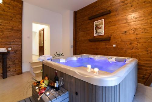 a large hot tub in a room with a wooden wall at Villa MOYA 1 in Fužine