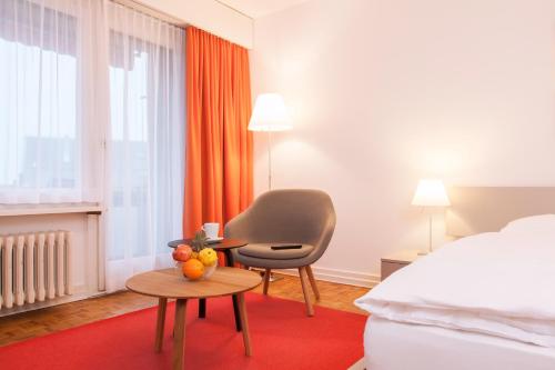 a hotel room with a bed and a chair and a table at CITY STAY - Nordstrasse in Zürich