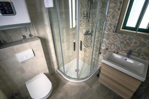 uma casa de banho com um chuveiro, um WC e um lavatório. em Apartments Korta em Split