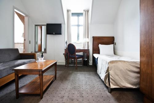 a hotel room with a bed and a couch and a table at Best Western Hotel Hebron in Copenhagen
