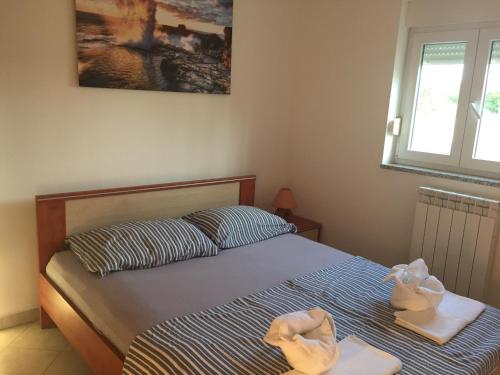 a bedroom with a bed with towels and a window at Sunny Rock Volme Apartments in Banjole