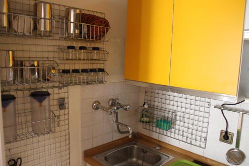 eine Küche mit einem Waschbecken und einem gelben Schrank in der Unterkunft Guesthouse48 in Bozen