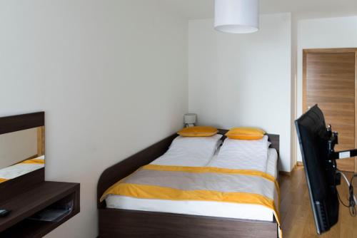 a small bedroom with a bed with orange pillows at Turistic Apartments Centar Sarajevo in Sarajevo
