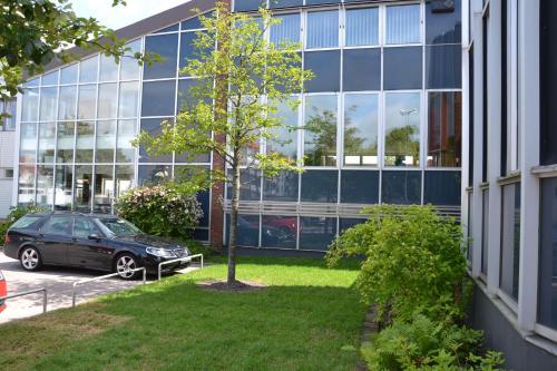 a car parked in front of a large building at STF Vandrarhem Oscar in Oskarshamn