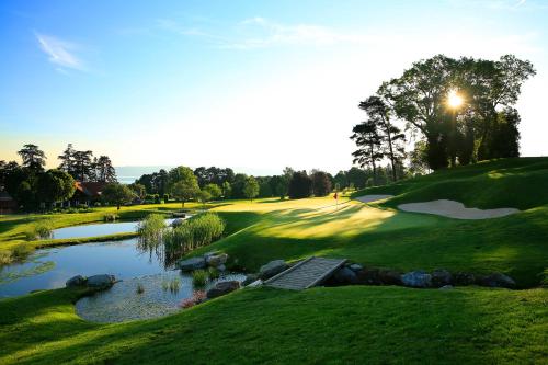 a view of a golf course with a pond at Hôtel Royal in Évian-les-Bains
