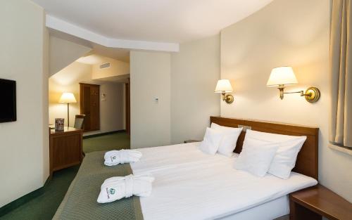 a hotel room with a bed with towels on it at Bukowy Park Hotel Medical SPA in Polanica-Zdrój