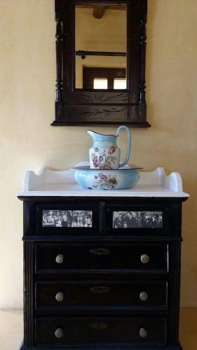 a dresser with a vase and a mirror on it at kritikies1 in Pitsidia