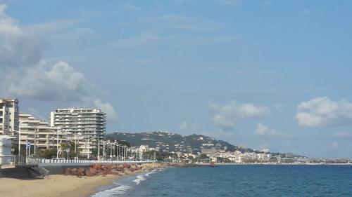a view of a beach with buildings and the ocean at Agréable chambre d'hôte à 50M de la mer in Cannes