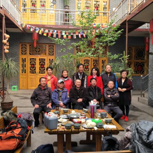 a group of people sitting around a table at Pingyao Jiaxin Guesthouse in Pingyao