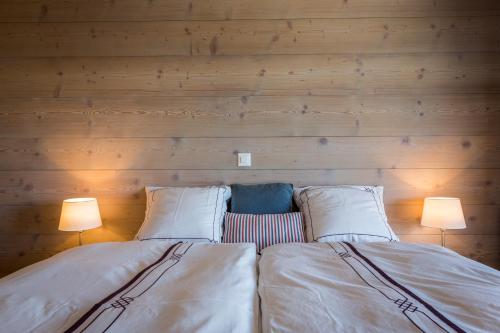 two beds in a room with two lamps at Apartment La Forêt 5 - Spa access - Centre Station in Nendaz