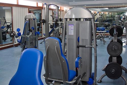 a gym with blue chairs and machines in it at Golden Coast Hotel in Baku