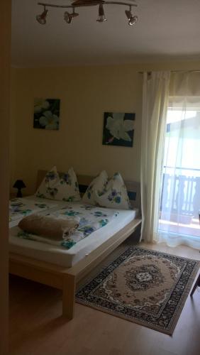 a bedroom with a bed and a window and a rug at Gästehaus Rosl in Reifnitz