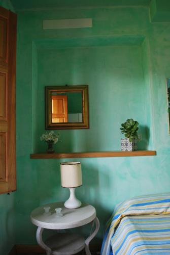 a room with a table with a mirror and a bed at Case Vacanze Fossanave in Santa Tecla