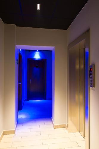 a blue corridor with a door in a building at Hotel San Francisco in Milan