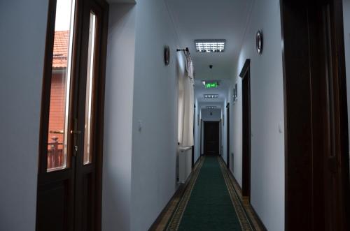 a long hallway with a green floor in a building at Pensiunea Zana Muntilor in Piatra Fantanele