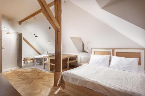 a bedroom with a bed and a bathroom with a sink at Hotel At the Golden Scissors in Prague