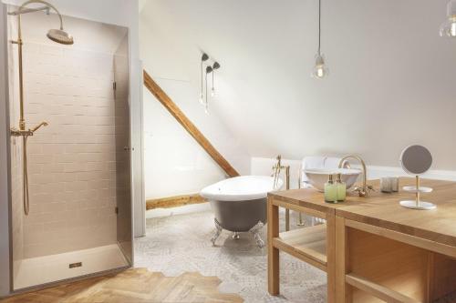 a bathroom with a tub and a toilet and a sink at Hotel At the Golden Scissors in Prague