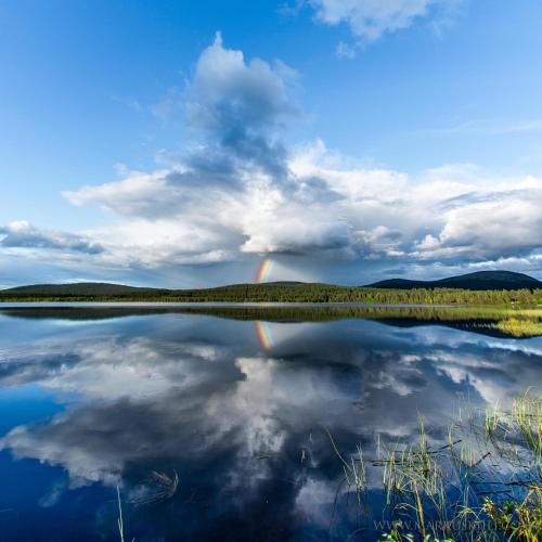 a reflection of the sky and clouds in a lake at Ylläksen Yöpuu in Äkäslompolo