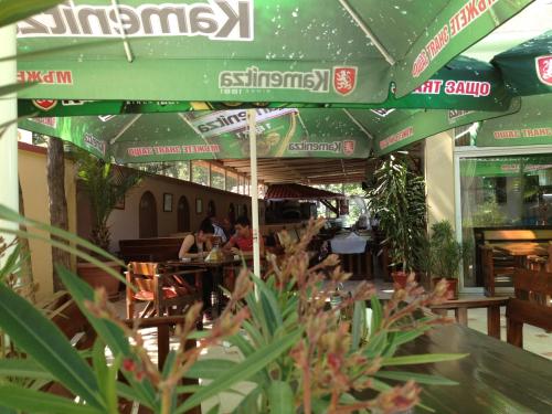 a restaurant with people sitting at tables under an umbrella at Family Hotel Diana in Tsarevo