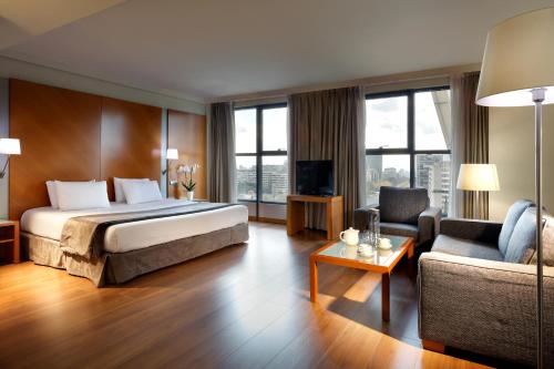 a hotel room with a bed and a couch at Exe Plaza in Madrid