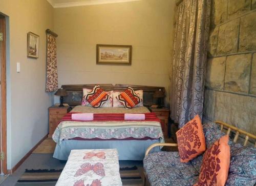 a bedroom with a bed and two chairs at Petra's Country Guesthouse in Vryheid