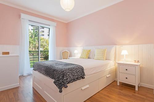 Un dormitorio con una cama grande y una ventana. en Ajuda II by An Island Apart, en Funchal