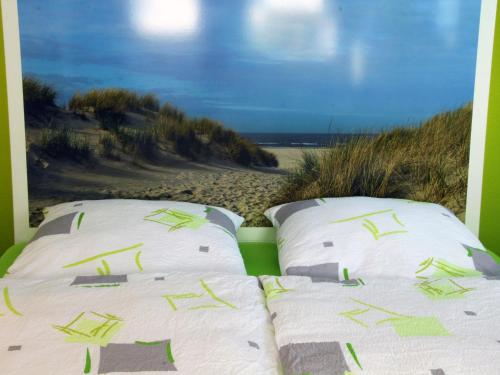 zwei Kissen auf einem Bett mit Strand in der Unterkunft Haus Hermann in Mederns