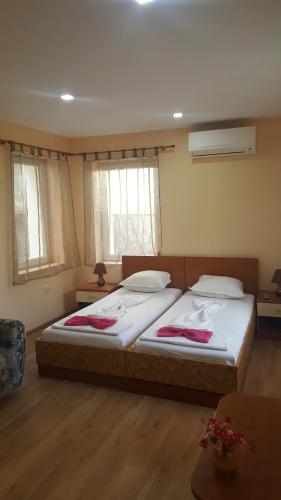 two twin beds in a room with two windows at Cathedral Guesthouse in Varna City